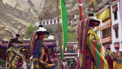 Tiro-Medio-De-Monjes-Con-Vestidos-Coloridos-Y-Sombreros-Bailando-En-El-Festival-Hemis-En-El-Monasterio