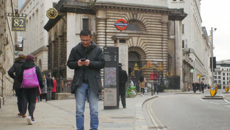 Hombre-Asiático-Decepcionado-Leyendo-Un-Mensaje-De-Texto-En-El-Distrito-Financiero-De-Londres