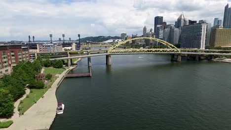 Carreras-De-Lanchas-Rápidas-Aéreas-Por-El-Río-Allegheny-Bajo-El-Puente-Fort-Duquesne-Hacia-El-Horizonte-De-La-Ciudad-De-Pittsburgh-Pennsylvania-Concepto:-Urbano,-Paisaje-Urbano,-Campos,-Drones,-Embarcaciones