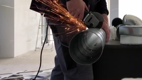 Plumber-uses-an-angle-grinder-to-cut-a-pipe