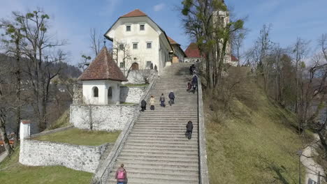 Flying-over-the-island-with-small-church-located-in-the-middle-of-the-Lake-Bled,-Slovenia