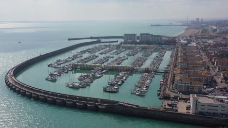 Wide-aerial-establishing-shot-of-Brighton-Marina,-pull-back-to-reveal-the-town,-Brighton-Pier---Beach,-the-English-Channel---the-i360-attraction