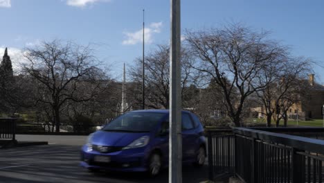 Vehicles-drive-past-ABC-roundabout-in-Hobart,-Tasmania,-on-sunny-winter-day