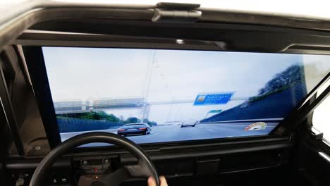 Child-wearing-cap-driving-a-car-simulator