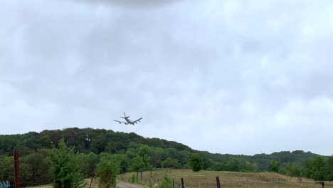 Un-Boeing-747-Cargolux-Aterrizando-Detrás-De-La-Línea-De-árboles-Bajo-La-Lluvia