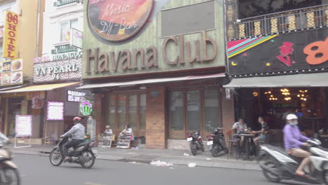 Panning-shot-of-Bui-Vien-Steet,-red-light-district,-Ho-Chi-Minh-City,-Saigon,-Vietnam-showing-the-businesses-along-the-street-and-the-traffic