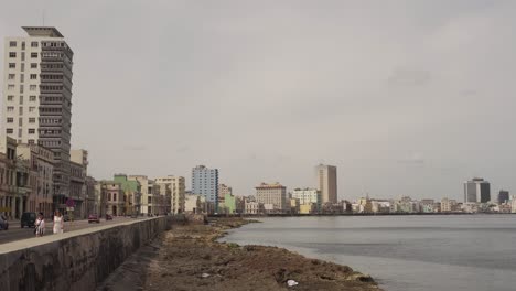 Promenade-of-famous-Malecon-in-Havana-during-day-with-locals-on-street,-Cuba