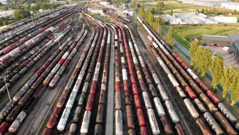 Toma-Aérea-Que-Muestra-Un-Gran-Depósito-De-Trenes-Con-Muchos-Trenes-De-Carga-Coloridos