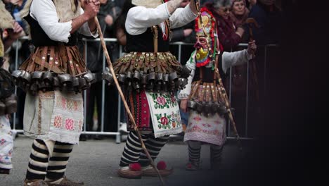 Dancing-masked-kuker-with-bells-on-his-chest-surrounded-by-crowd