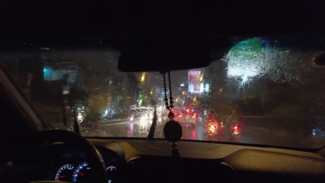 View-through-Taxi-window-in-pouring-tropical-rain-at-night-with-the-dazzling-lights-of-Ho-Chi-Minh-City-on-Saturday-night