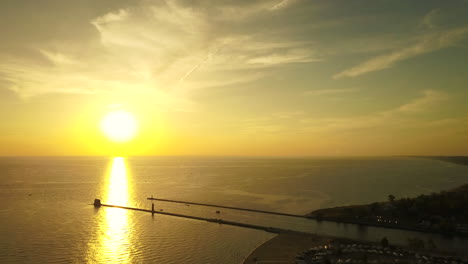 Aerial-view-of-sunset-by-pier-and-lighthouse-at-Grand-Haven,-Michigan,-USA