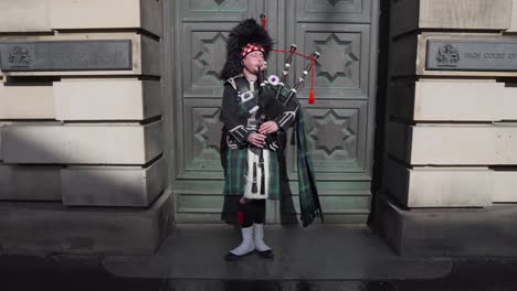 Estática-De-Un-Músico,-Gaitero-Con-Una-Falda-Escocesa-Y-Actuando-En-Las-Calles-De-Edimburgo,-Escocia-En-El-Casco-Antiguo-Tocando-La-Gaita-En-Un-Día-Soleado