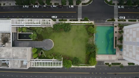 Top-down-tracking-Aerial-shot-featuring-rooftop-gardens,-swimming-pools-and-streets-of-contemporary-luxury-residential-real-estate-development-in-Thu-Thiem,-district-2-of-Ho-Chi-Minh-City