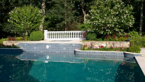 Aerial-flyover-of-a-turquoise-pool-and-hot-tub-spa-area,-forward