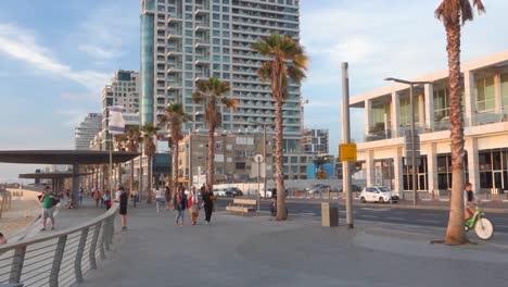 People-cycling,-running-and-walking-on-a-street-near-the-beach-in-Tel-Aviv,-Israel