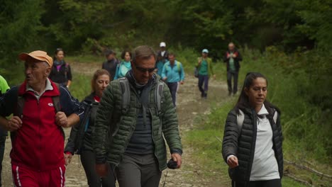 A-large-group-of-people-walk-together-on-a-trail-at-Via-Transylvania,-Romania