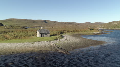 Una-Vista-Aérea-De-Una-Pequeña-Cabaña-De-Montaña-En-La-Bahía-De-Laxford-En-Un-Día-Soleado-De-Verano