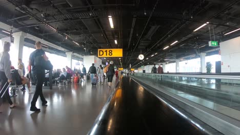 People-traveling-with-luggage-inside-an-airport-in-time-lapse