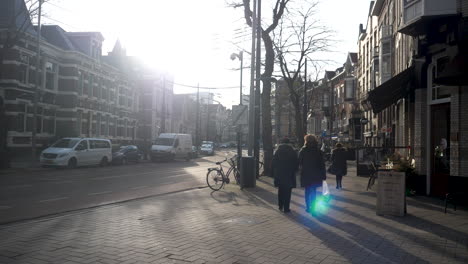 Zwei-Fußgängerinnen-Gehen-Eine-Straße-Entlang,-Während-Die-Sonne-Aufleuchtet