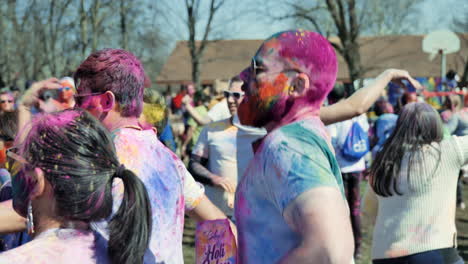 Handheld-shot-of-dancer-blowing-powder-at-Holi-festival