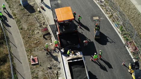 Vista-Aérea-De-Un-Equipo-De-Pavimentación-De-Carreteras-Que-Coloca-Asfalto-En-Una-Carretera-Nueva