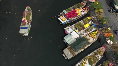 Vista-Aérea-Siguiendo-Un-Barco-A-Lo-Largo-Del-Mercado-Flotante-De-Flores-En-Saigón-O-Ciudad-Ho-Chi-Minh-En-Vietnam