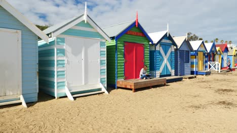 Tourists-walking-and-taking-photo-at-Brighton-Bathing-Boxes,-Melbourne,-Australia