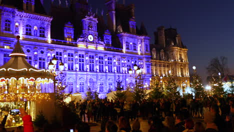 Mercados-Iluminados-De-Navidad-En-Una-Hermosa-Parte-De-París-Con-Mapeo-De-Video-De-Características-Dominantes-Con-El-Tema-De-La-Nieve-Que-Cae-En-Uno-De-Los-Edificios-Principales-En-Los-Mercados-Centrales-Con-Una-Multitud-De-Visitantes-Mirando