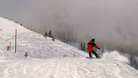 Wide-angle-shot-of-a-person-snow-boarding-downhill-wearing-skiing-gear-at-a-skiing-resort-in-Wagrain-with-beautiful-snow-covered-mountains-and-dramatic-clouds-in-the-background