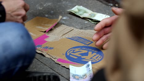 Hombres-Jugando-Y-Apostando-En-Un-Juego-De-Cartas-En-Un-Callejón,-El-Dinero-Renminbi-Se-Coloca-En-Una-Caja-De-Cartón-China-De-Chongqing,-Toma-De-Primer-Plano-Bloqueada