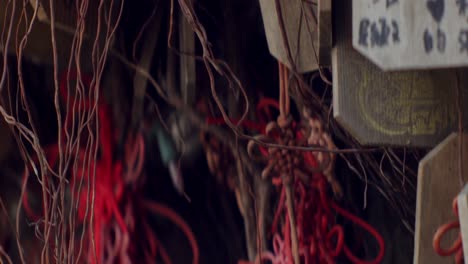 Variety-of-wooden-assorted-wish,-blessing-cards-hanging-from-spiritual-tree-with-red-ribbon,-Taiwan