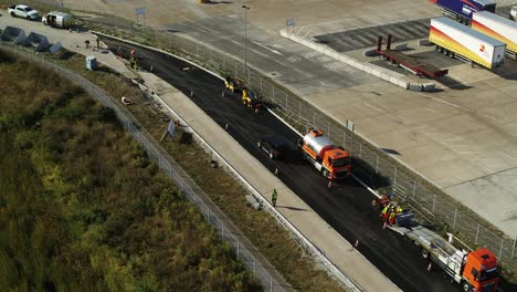 Toma-Aérea-Rastreando-Un-Vehículo-Terrestre-A-Través-De-Obras-Viales-Hasta-Un-Estacionamiento