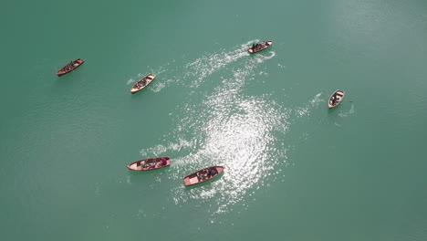 Grupo-De-Navegantes-De-Remos-Remando-En-El-Lago-Braies,-También-Conocido-Como-Pragser-Wildsee,-Tiro-De-Elevación-De-Vista-Superior-Aérea