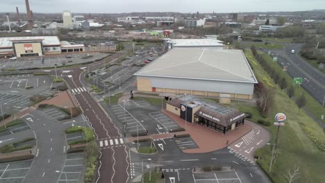 Corona-virus-lockdown-town-empty-retail-area-shopping-aerial-view-pan-left-across-empty-store-car-park