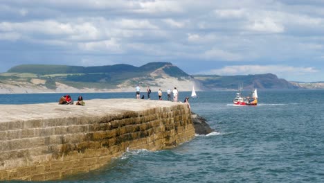 Ein-Fischerboot-Kehrt-An-Einem-Sonnigen-Tag-Vor-Der-Kulisse-Der-Juraküste-In-Den-Hafen-Zurück