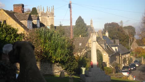 War-memorial-and-St-James'-church-with-poppy-wreaths-ready-for-Armistice-day-in-Longborough,-a-small-village-near-Moreton-In-Marsh-in-the-Cotswolds-Area-Of-Outstanding-Natural-Beauty,-UK