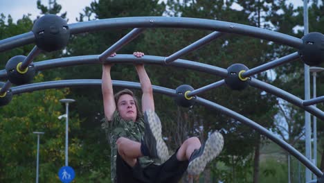 Junge-übt-Parkour-Hanging-Stunts,-Während-Menschen-In-Einem-Park-In-Der-Stadt-Cluj,-Napoca,-Rumänien,-Zuschauen-–-Nahaufnahme