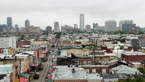 Luftaufnahme-Des-Italienischen-Marktes-Und-Der-Ladenvordächer-Im-Stadtteil-South-Philadelphia,-Skyline-Der-Stadt-In-Der-Ferne