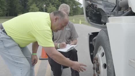 CDL-truck-driving-student-completes-his-walk-around-exam-with-a-driving-test-administrator