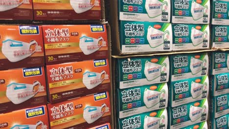 Muchas-Cajas-De-Máscaras-Faciales-Desechables-Apiladas-Y-Exhibidas-En-El-Estante-De-Un-Supermercado-Durante-El-Covid-19-En-Tokio,-Japón