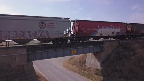 Antena-De-Ligera-Subida:-El-Tren-Con-Graffiti-Cruza-Un-Pequeño-Puente-Sobre-La-Carretera