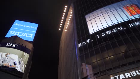 Panorámica-Lenta-Hacia-La-Derecha-Mirando-Hacia-Arriba-En-Vallas-Publicitarias-En-El-Cruce-De-Shibuya-Por-La-Noche