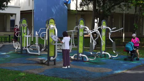 Grupo-Multigeneracional-En-Un-Rincón-De-Fitness,-Ejercicio-Al-Aire-Libre-En-Hdb-Estate