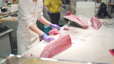 Person,-Die-Vor-Der-Öffentlichkeit-Auf-Dem-Toretore-Ichiba-Fischmarkt-In-Wakayama,-Japan,-Frischen-Roten-Thun-Mit-Einem-Metzgermesser-Schneidet