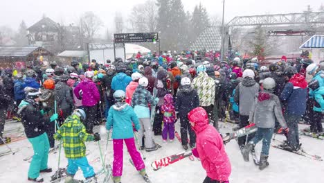 Tourists-and-skiers-queuing-up-to-the-Szrenica-mountain-chairlift-in-Szklarska-Poreba-resort-during-winter-school-holidays,-Karkonosze-mountains,-Poland