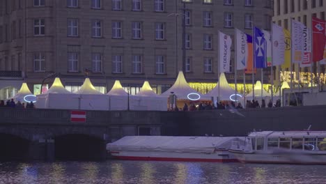 Panning-view-of-the-lit-up-tents-at-the-Christmas-market-at-Binnenalster-in-Hamburg,-Germany,-in-Dec-2019