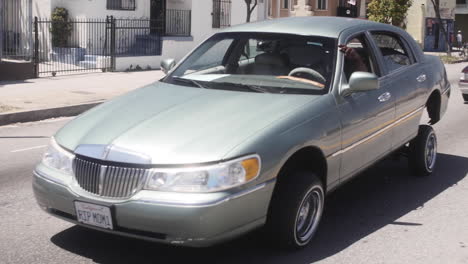 Classic-Classic-Lincoln-Continental,-Car-Cruising-on-Hydraulics-at-Car-Show-in-Street,-RIP-Mom-License-Plate