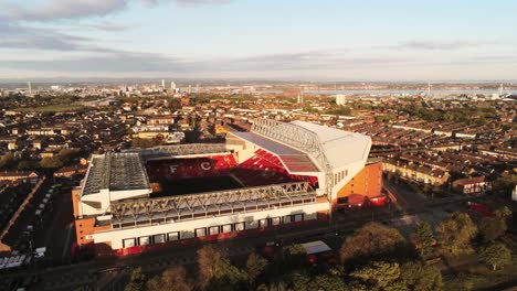 Das-Ikonische-Stadiongelände-Des-Anfield-Fußballstadions-Von-Liverpool-Bei-Sonnenaufgang,-Luftaufnahme,-Weite-Umlaufbahn-Nach-Links