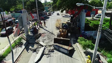 Vista-Aérea-De-Una-Excavadora-Limpiando-La-Escena-De-Un-Accidente-De-Tráfico,-En-Una-Ciudad,-En-México,-Centroamérica---Reversa,-Disparo-De-Drones