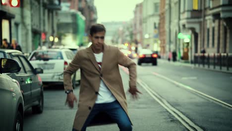 Un-Joven-Apuesto-Bailando-En-Medio-De-Una-Carretera-En-Una-Ciudad-Europea-Por-La-Noche